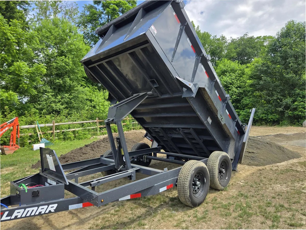 Mainline hydraulic dump trailer dumping a load of soil on a job site in Poughquag NY
