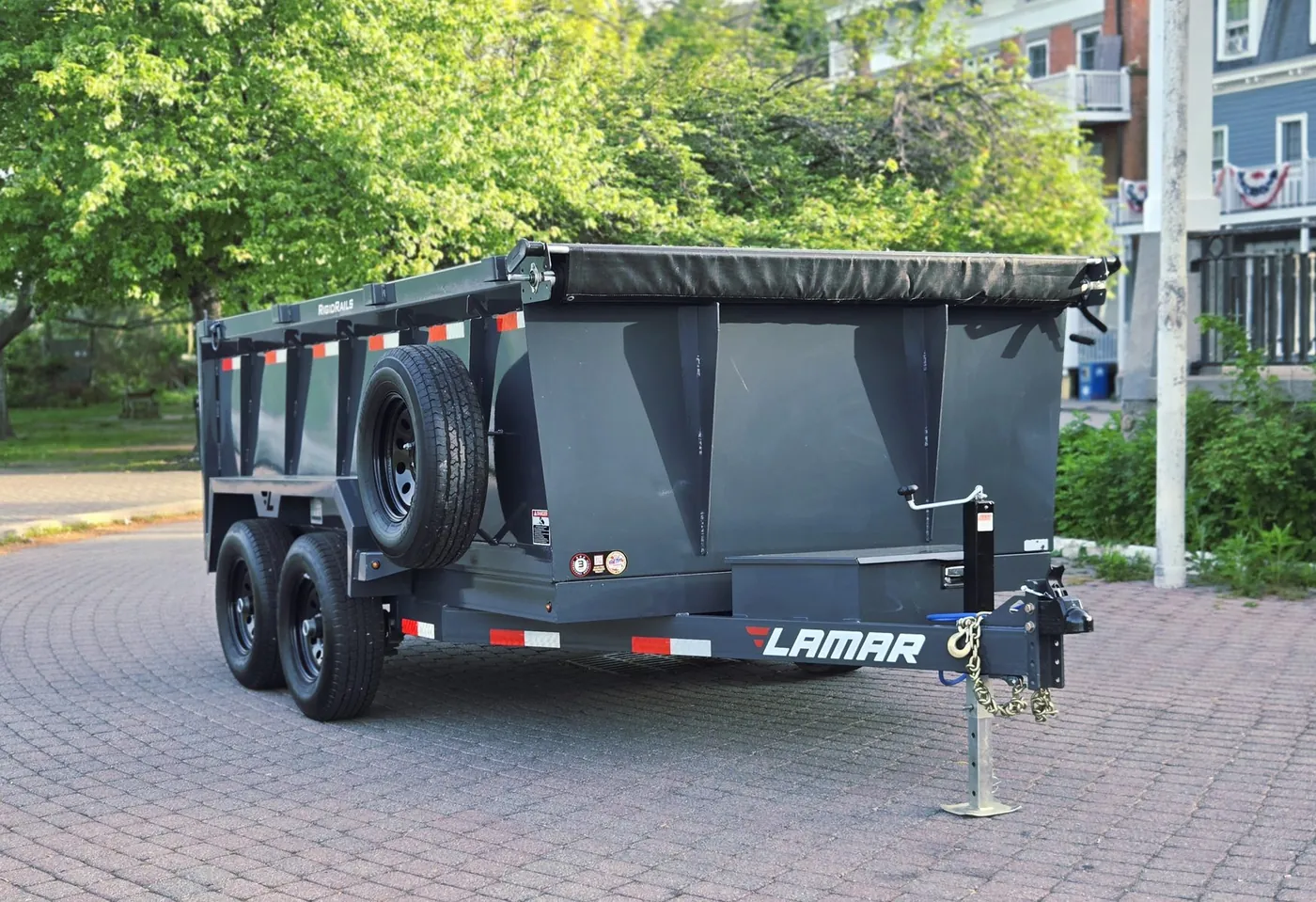 Lamar 77-inch by 12-foot hydraulic dump trailer rental on a residential paver driveway, Hudson Valley NY
